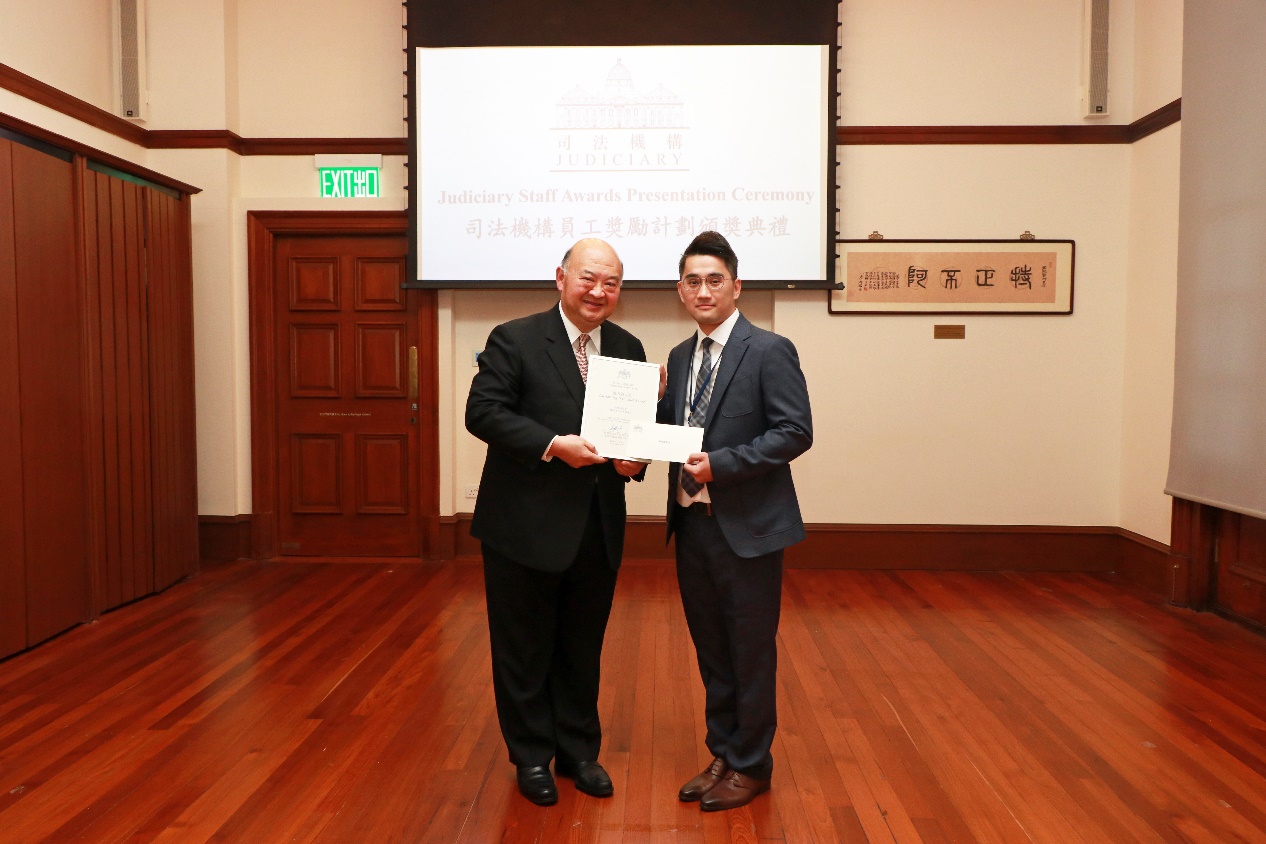 終審法院首席法官馬道立恭賀獲頒授「傑出個人獎」的助理文書主任吳坤誠